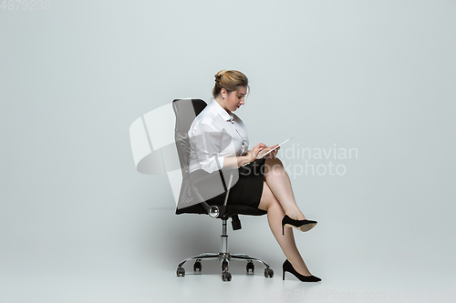 Image of Young caucasian woman in office attire on gray background. Bodypositive female character. plus size businesswoman