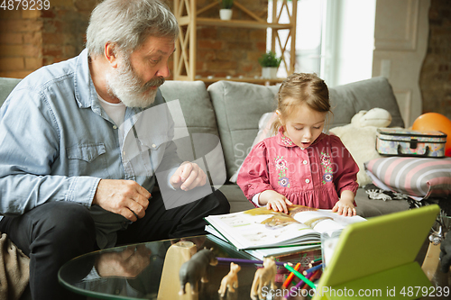 Image of Grandfather and child playing together at home. Happiness, family, relathionship, education concept.