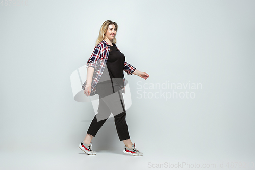 Image of Young caucasian woman in casual wear on gray background. Bodypositive female character, plus size businesswoman