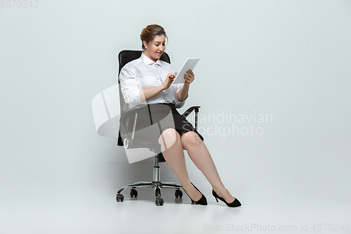 Image of Young caucasian woman in office attire on gray background. Bodypositive female character. plus size businesswoman