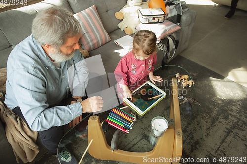 Image of Grandfather and child playing together at home. Happiness, family, relathionship, education concept.