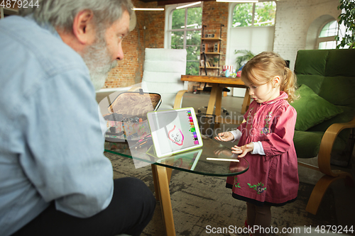 Image of Grandfather and child playing together at home. Happiness, family, relathionship, education concept.