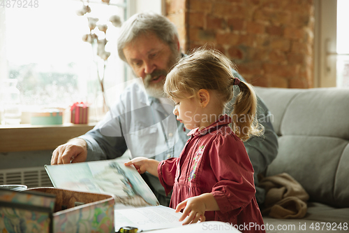 Image of Grandfather and child playing together at home. Happiness, family, relathionship, education concept.