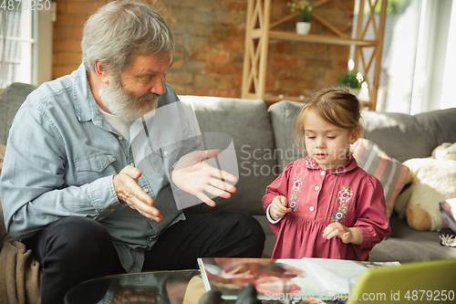Image of Grandfather and child playing together at home. Happiness, family, relathionship, education concept.