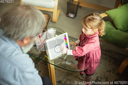 Image of Grandfather and child playing together at home. Happiness, family, relathionship, education concept.