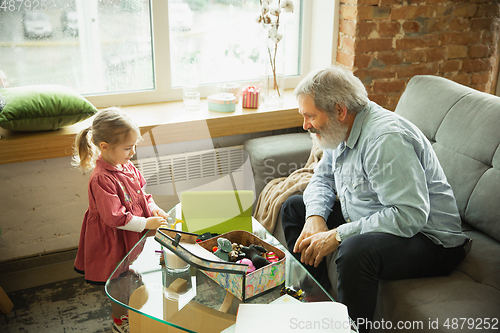 Image of Grandfather and child playing together at home. Happiness, family, relathionship, education concept.