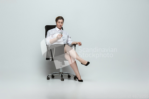 Image of Young caucasian woman in office attire on gray background. Bodypositive female character. plus size businesswoman