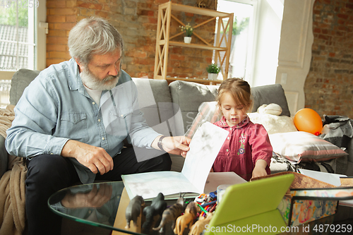 Image of Grandfather and child playing together at home. Happiness, family, relathionship, education concept.