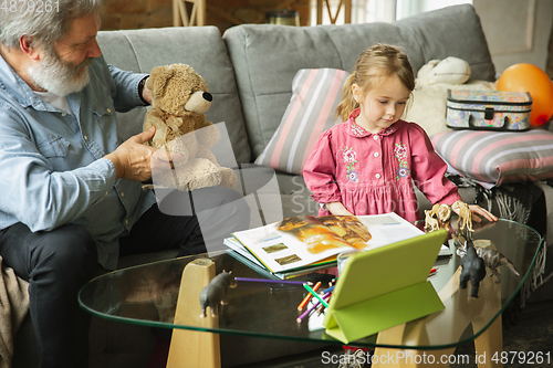 Image of Grandfather and child playing together at home. Happiness, family, relathionship, education concept.