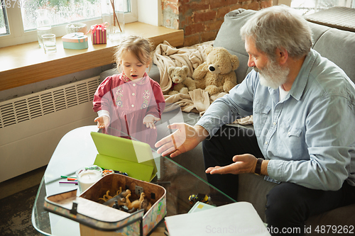 Image of Grandfather and child playing together at home. Happiness, family, relathionship, education concept.