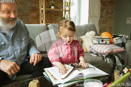 Image of Grandfather and child playing together at home. Happiness, family, relathionship, education concept.