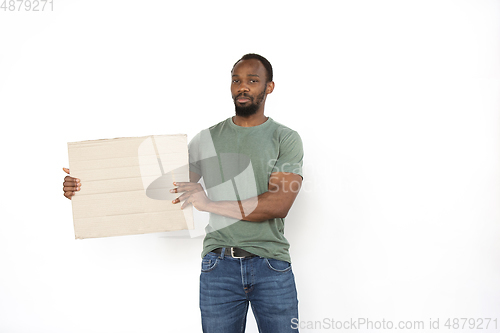 Image of Young man protesting with blank board, sign isolated on white studio background