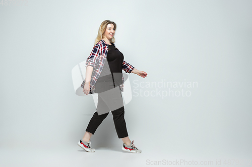 Image of Young caucasian woman in casual wear on gray background. Bodypositive female character, plus size businesswoman