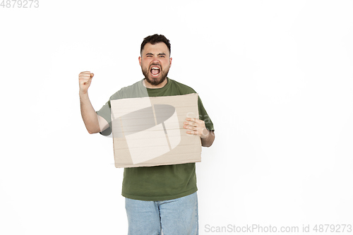 Image of Young man protesting with blank board, sign isolated on white studio background