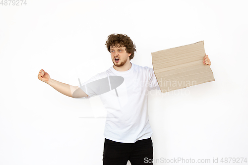 Image of Young man protesting with blank board, sign isolated on white studio background