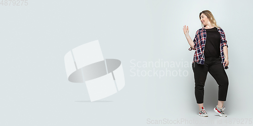 Image of Young caucasian woman in casual wear on gray background. Bodypositive female character, plus size businesswoman