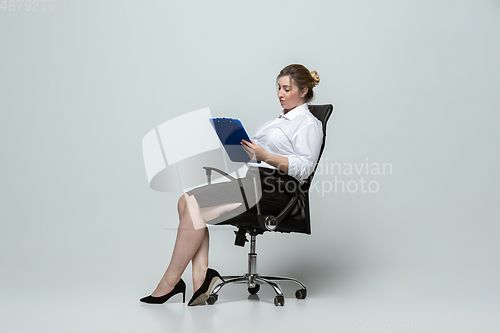 Image of Young caucasian woman in office attire on gray background. Bodypositive female character. plus size businesswoman