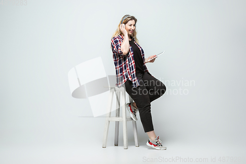 Image of Young caucasian woman in casual wear on gray background. Bodypositive female character, plus size businesswoman