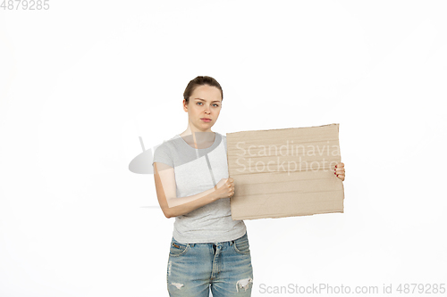 Image of Young woman protesting with blank board, sign isolated on white studio background