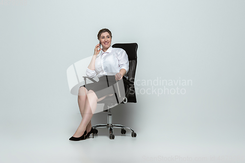 Image of Young caucasian woman in office attire on gray background. Bodypositive female character. plus size businesswoman