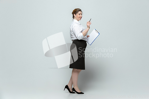 Image of Young caucasian woman in office attire on gray background. Bodypositive female character. plus size businesswoman