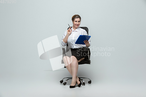 Image of Young caucasian woman in office attire on gray background. Bodypositive female character. plus size businesswoman