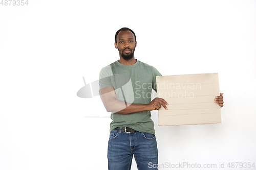 Image of Young man protesting with blank board, sign isolated on white studio background