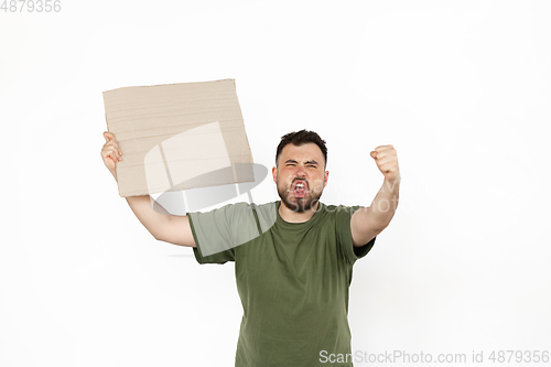 Image of Young man protesting with blank board, sign isolated on white studio background