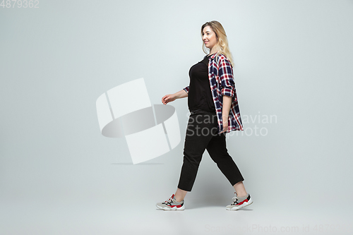 Image of Young caucasian woman in casual wear on gray background. Bodypositive female character, plus size businesswoman