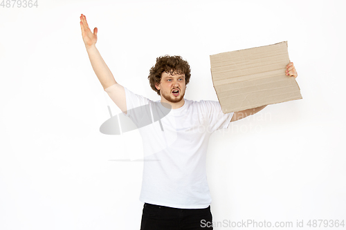 Image of Young man protesting with blank board, sign isolated on white studio background