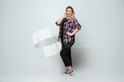 Image of Young caucasian woman in casual wear on gray background. Bodypositive female character, plus size businesswoman