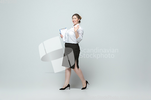 Image of Young caucasian woman in office attire on gray background. Bodypositive female character. plus size businesswoman