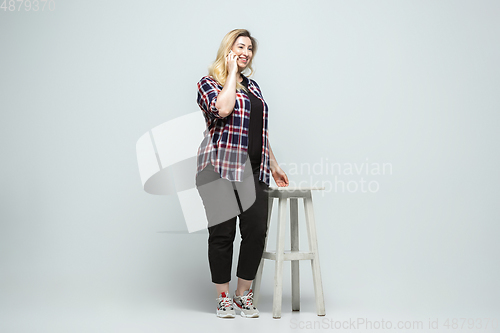 Image of Young caucasian woman in casual wear on gray background. Bodypositive female character, plus size businesswoman