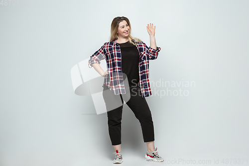 Image of Young caucasian woman in casual wear on gray background. Bodypositive female character, plus size businesswoman