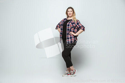 Image of Young caucasian woman in casual wear on gray background. Bodypositive female character, plus size businesswoman