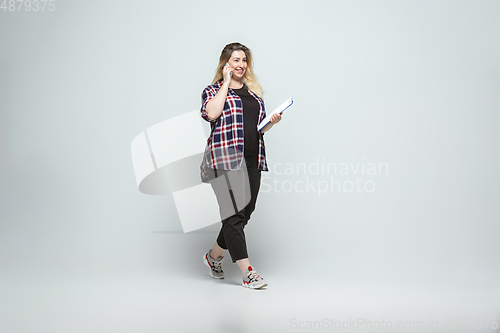 Image of Young caucasian woman in casual wear on gray background. Bodypositive female character, plus size businesswoman