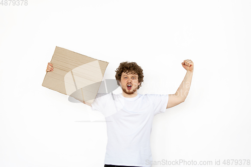 Image of Young man protesting with blank board, sign isolated on white studio background