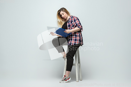 Image of Young caucasian woman in casual wear on gray background. Bodypositive female character, plus size businesswoman