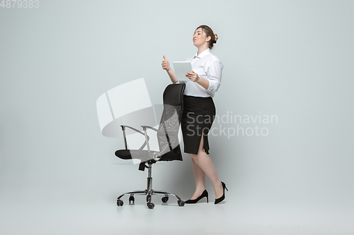 Image of Young caucasian woman in office attire on gray background. Bodypositive female character. plus size businesswoman