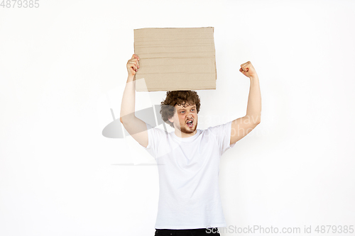 Image of Young man protesting with blank board, sign isolated on white studio background