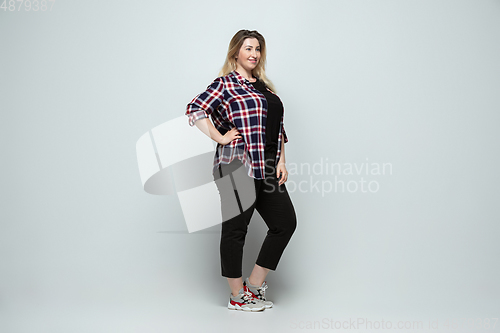 Image of Young caucasian woman in casual wear on gray background. Bodypositive female character, plus size businesswoman