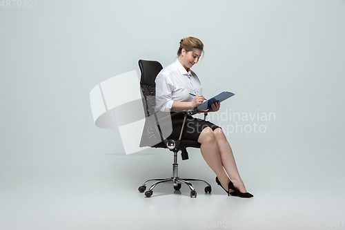 Image of Young caucasian woman in office attire on gray background. Bodypositive female character. plus size businesswoman