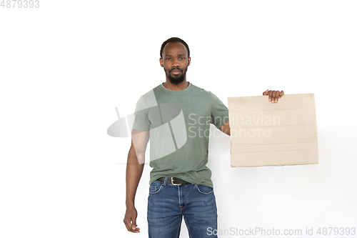 Image of Young man protesting with blank board, sign isolated on white studio background