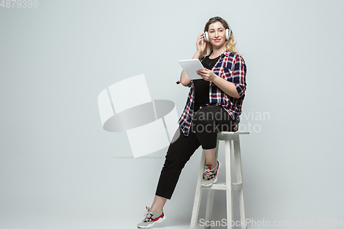 Image of Young caucasian woman in casual wear on gray background. Bodypositive female character, plus size businesswoman