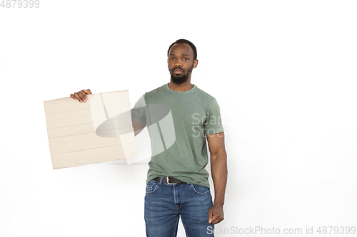 Image of Young man protesting with blank board, sign isolated on white studio background