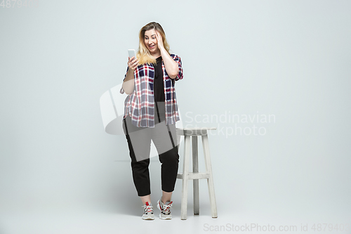 Image of Young caucasian woman in casual wear on gray background. Bodypositive female character, plus size businesswoman