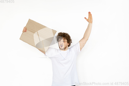 Image of Young man protesting with blank board, sign isolated on white studio background