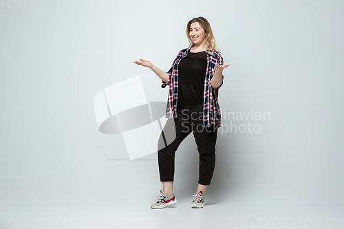 Image of Young caucasian woman in casual wear on gray background. Bodypositive female character, plus size businesswoman