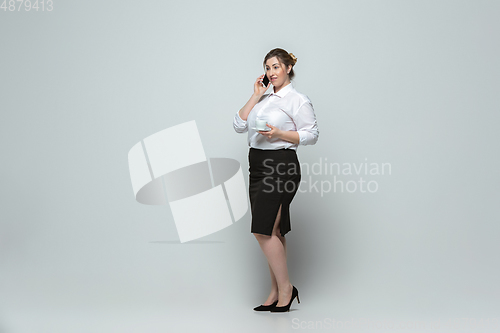 Image of Young caucasian woman in office attire on gray background. Bodypositive female character. plus size businesswoman
