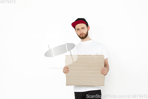 Image of Young man protesting with blank board, sign isolated on white studio background